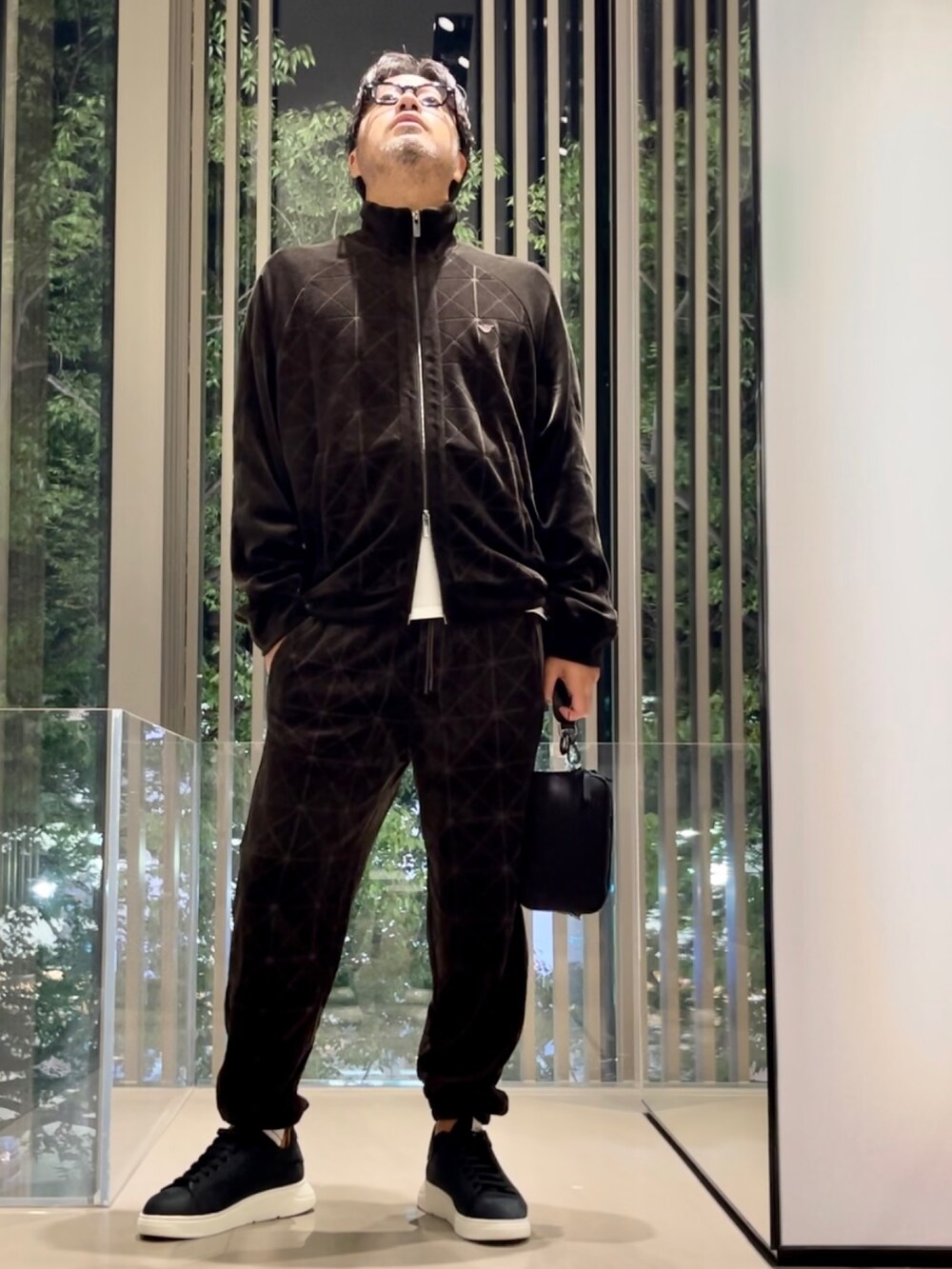 ホワイト系のTシャツ/カットソー、グリーン系のスウェットパンツ、ブラック系のスニーカーを着用したメンズの秋コーディネートの2枚目の写真