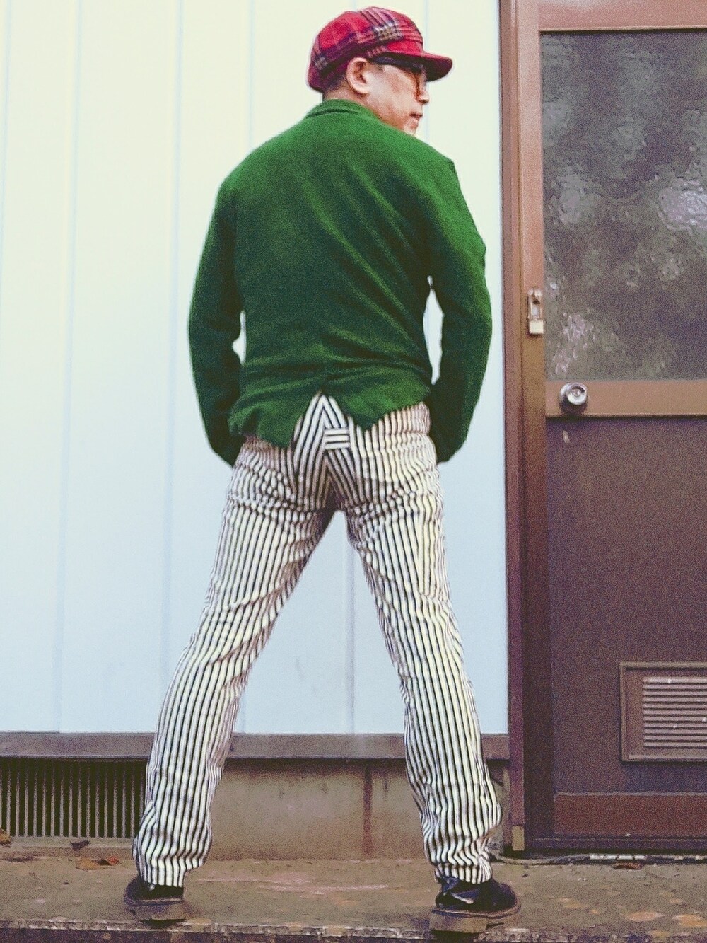 グリーン系のテーラードジャケット、ホワイト系のスラックス、レッド系のネクタイを着用したメンズの秋コーディネートの4枚目の写真