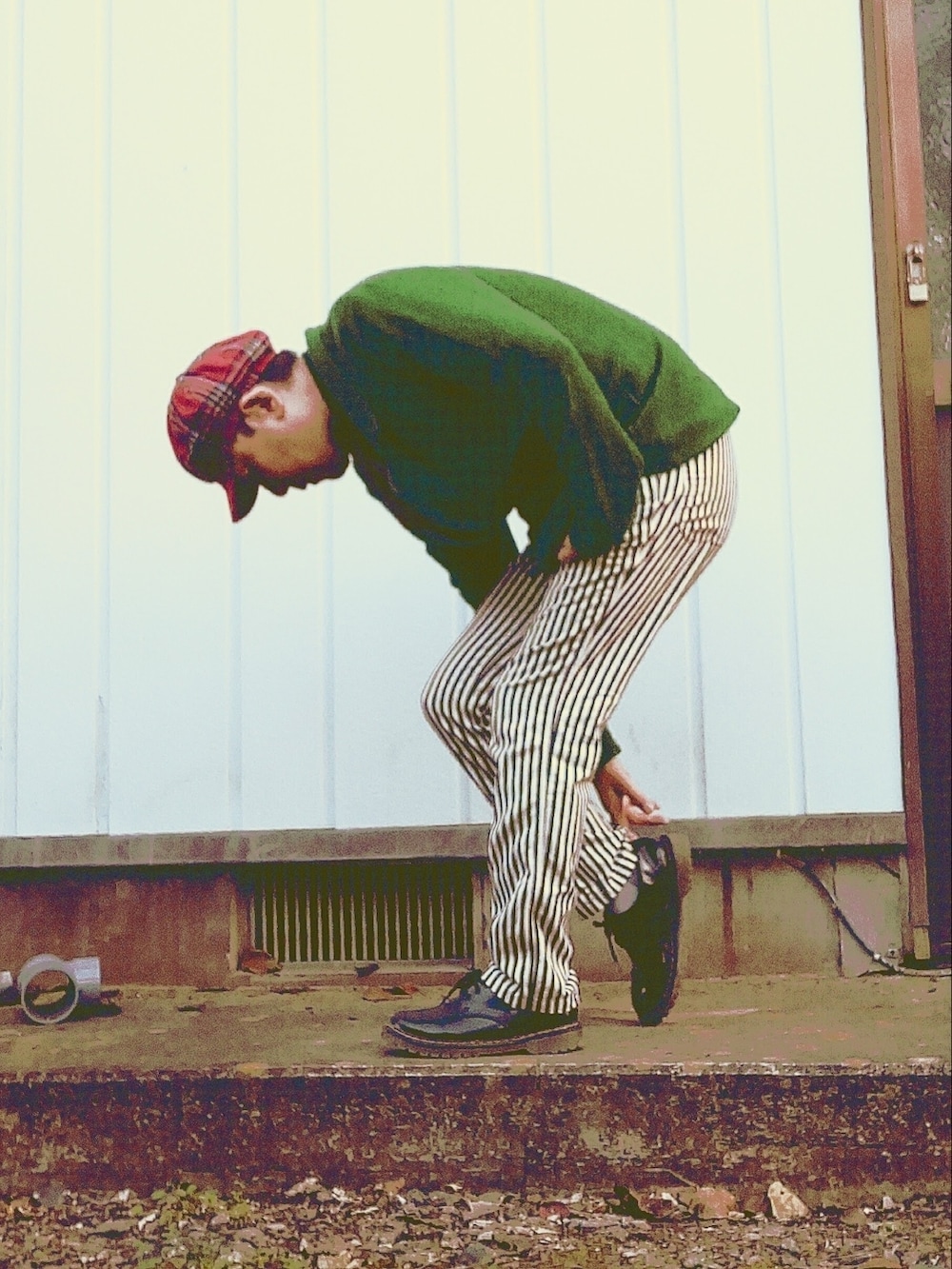 グリーン系のテーラードジャケット、ホワイト系のスラックス、レッド系のネクタイを着用したメンズの秋コーディネートの3枚目の写真