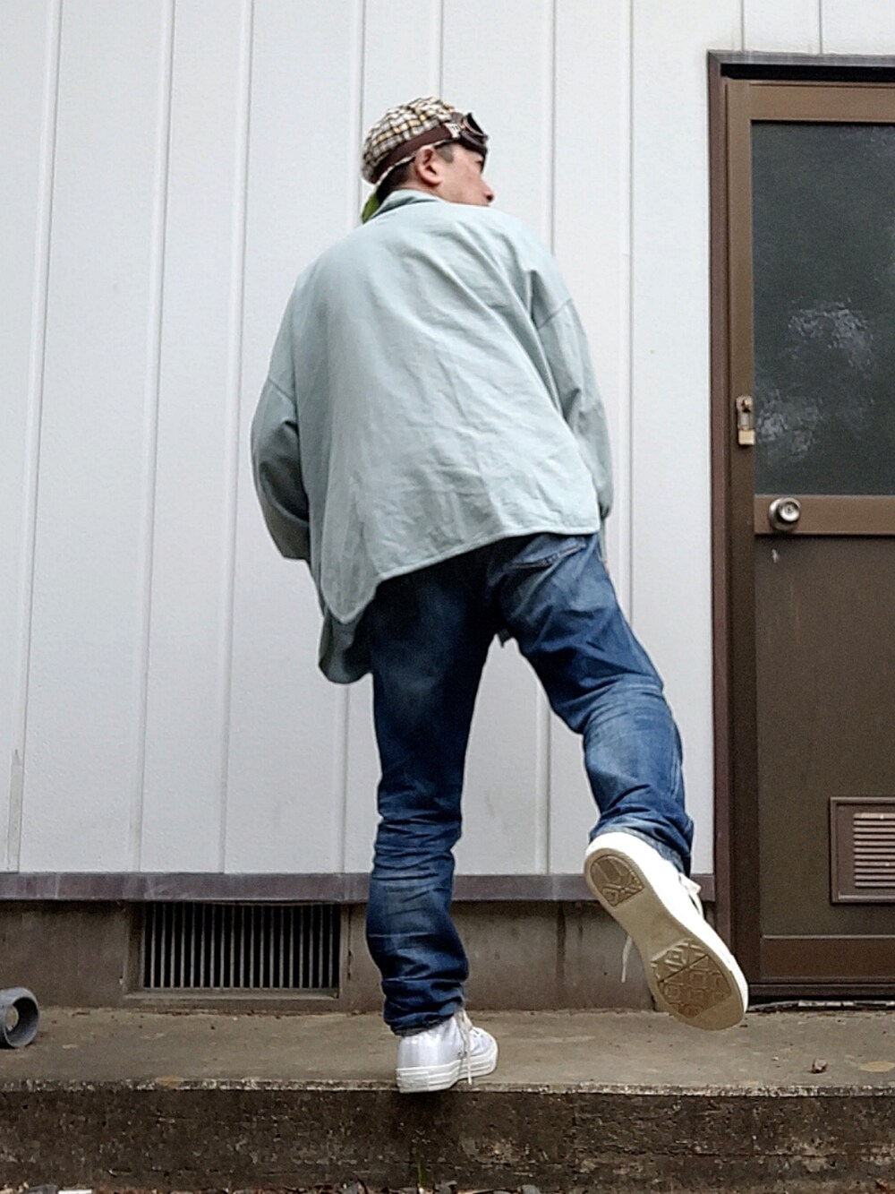 ホワイト系のTシャツ/カットソー、ブルー系のデニムパンツ、ホワイト系のスニーカーを着用したメンズの春コーディネートの2枚目の写真