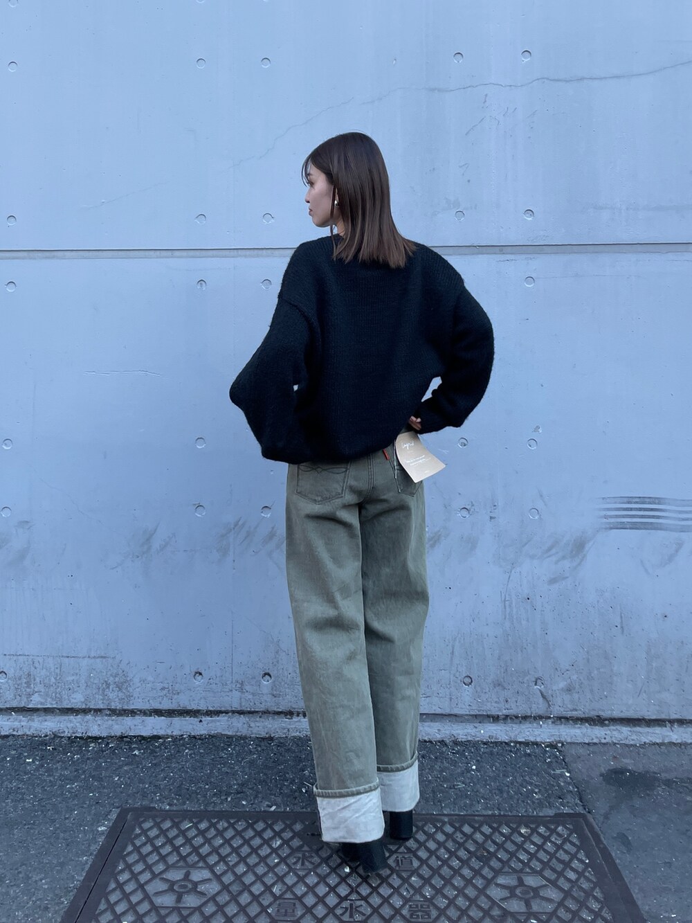 ブラック系のニット/セーター、グリーン系のデニムパンツを着用したレディースの冬コーディネートの4枚目の写真