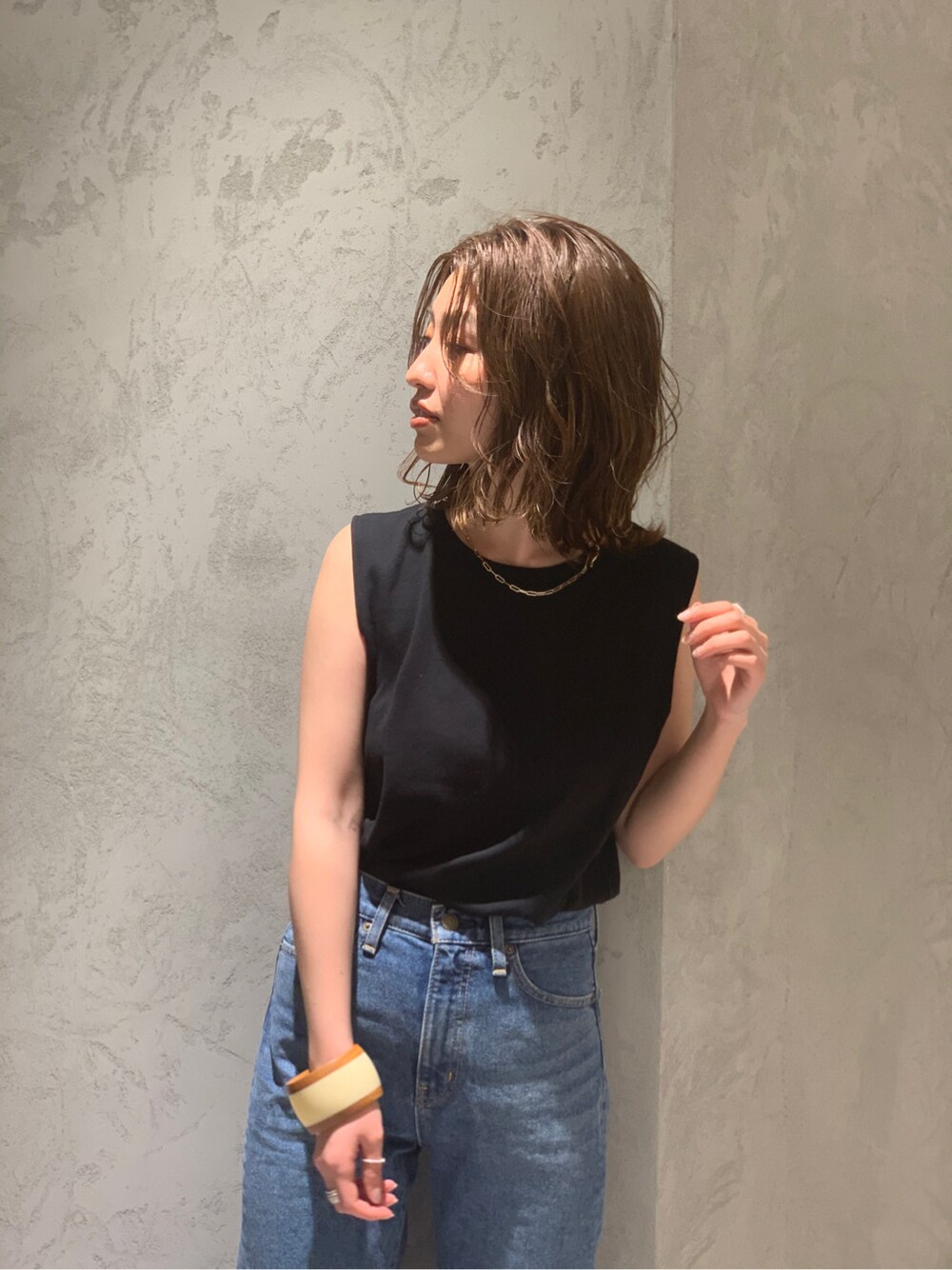 ブルー系のデニムパンツ、ブラック系のタンクトップ、その他のバングル/リストバンドを着用したレディースの春コーディネートの2枚目の写真