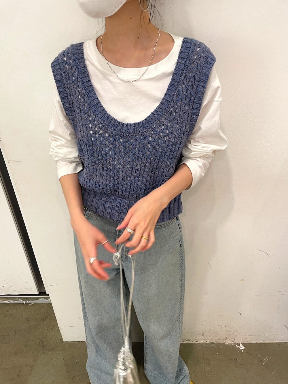 ブルー系のデニムパンツ、ゴールド系のパンプス、ホワイト系のTシャツ/カットソーを着用したレディースの冬コーディネートの3枚目の写真