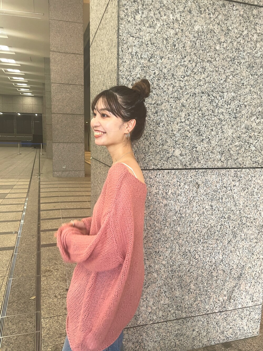 ピンク系のニット/セーター、ブルー系のデニムパンツを着用したレディースの秋コーディネートの3枚目の写真
