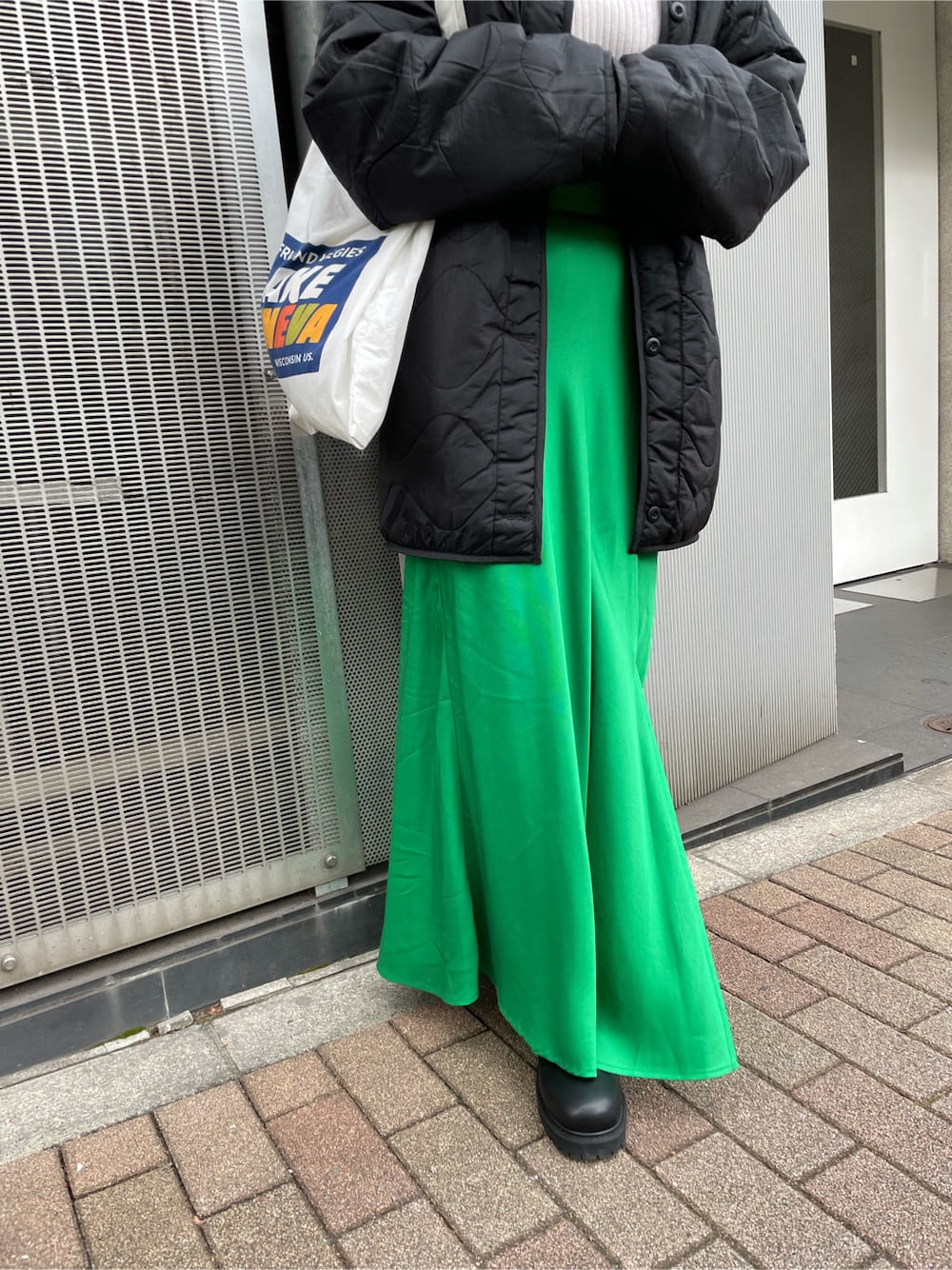 グリーン系のスカート、ブラック系のブーツ、ホワイト系のエコバッグ/サブバッグを着用したレディースの秋コーディネートの4枚目の写真