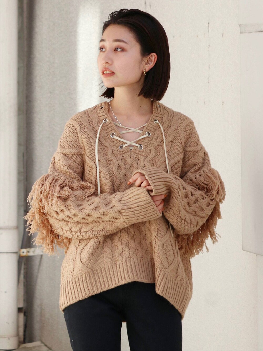 ブラック系のデニムパンツ、ベージュ系のニット/セーターを着用したレディースの冬コーディネートの2枚目の写真