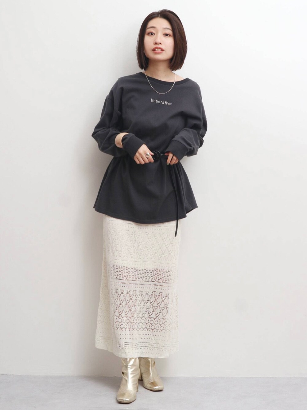 ホワイト系のスカート、ブラック系のベルトを着用したレディースの冬コーディネートの2枚目の写真