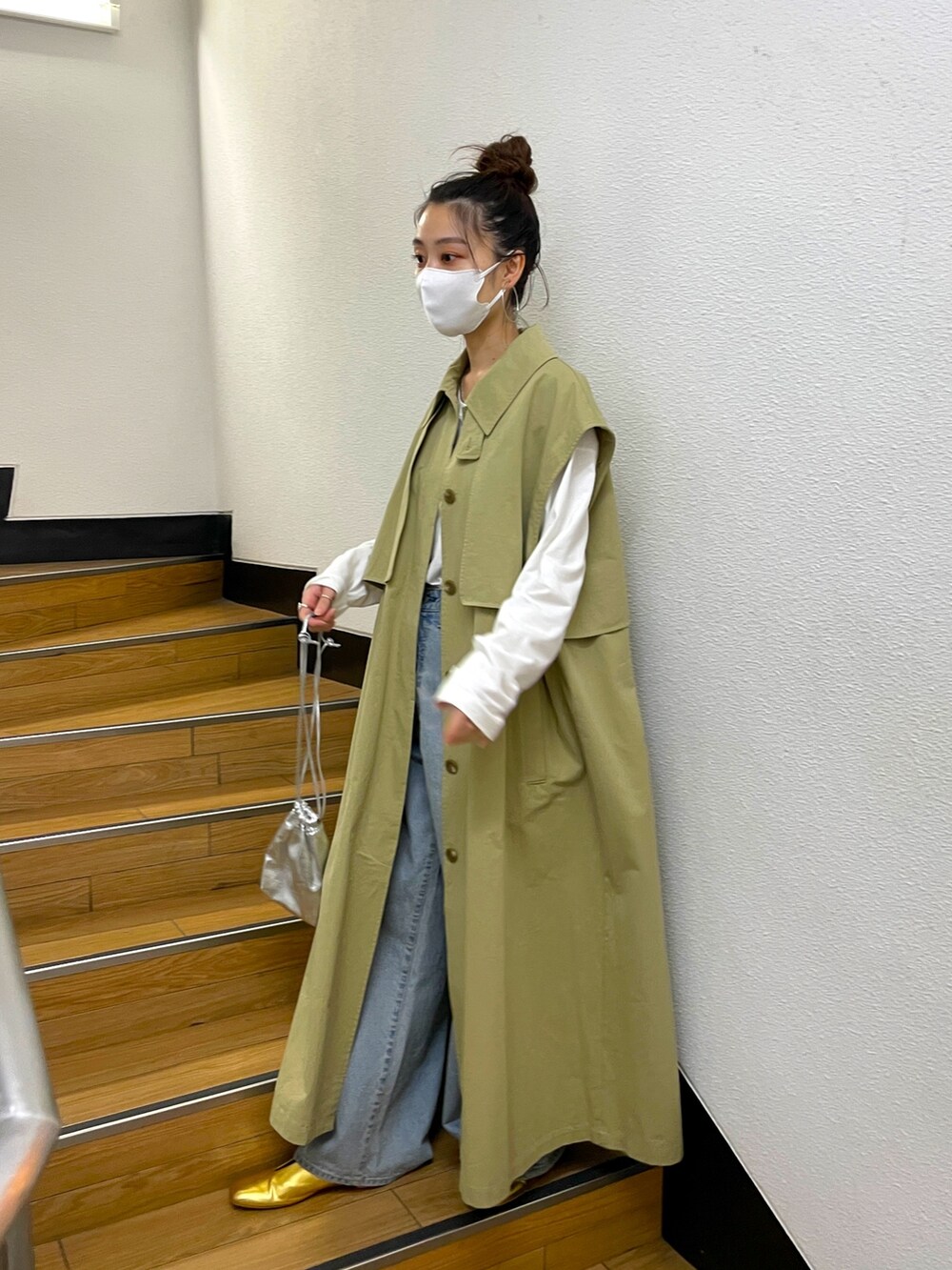 ベージュ系のその他アウター、ブルー系のデニムパンツ、ゴールド系のパンプスを着用したレディースの冬コーディネートの2枚目の写真