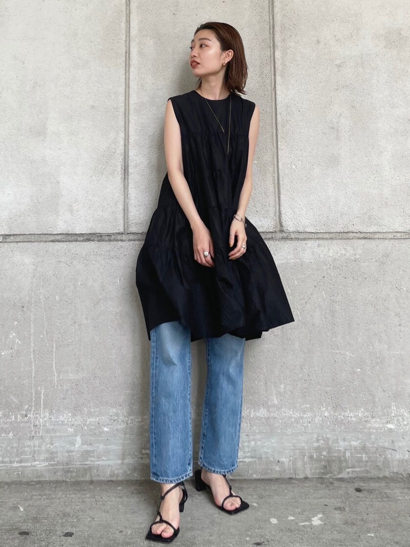 ブルー系のデニムパンツ、ブラック系のワンピース、ブラック系のサンダルを着用したレディースの夏コーディネートの3枚目の写真