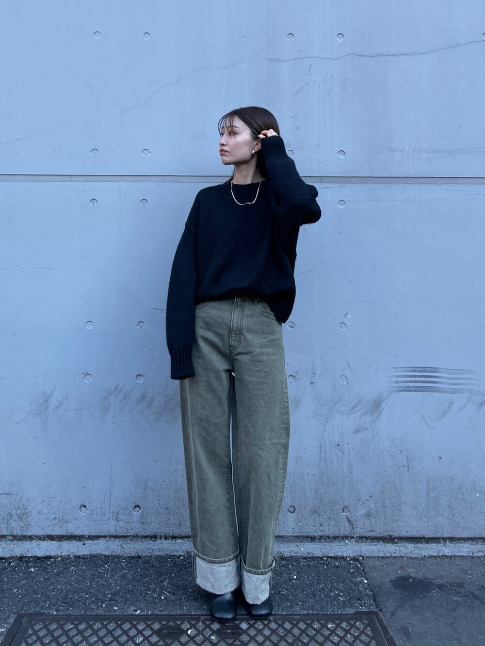 ブラック系のニット/セーター、グリーン系のデニムパンツを着用したレディースの冬コーディネートの3枚目の写真