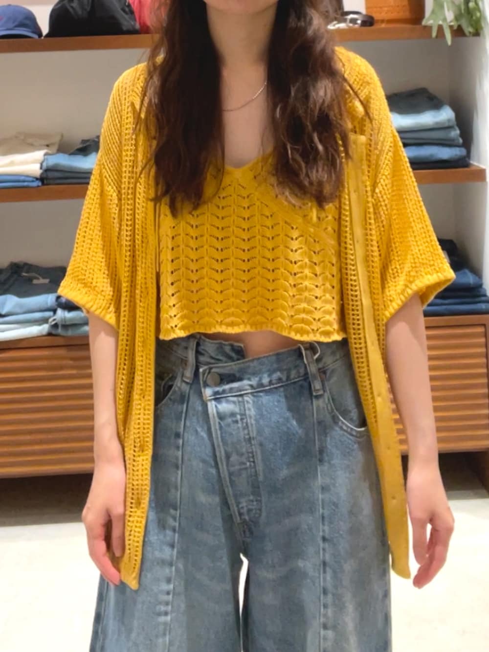 オレンジ系のカーディガン/ボレロ、ブルー系のデニムパンツを着用したレディースの春コーディネートの5枚目の写真