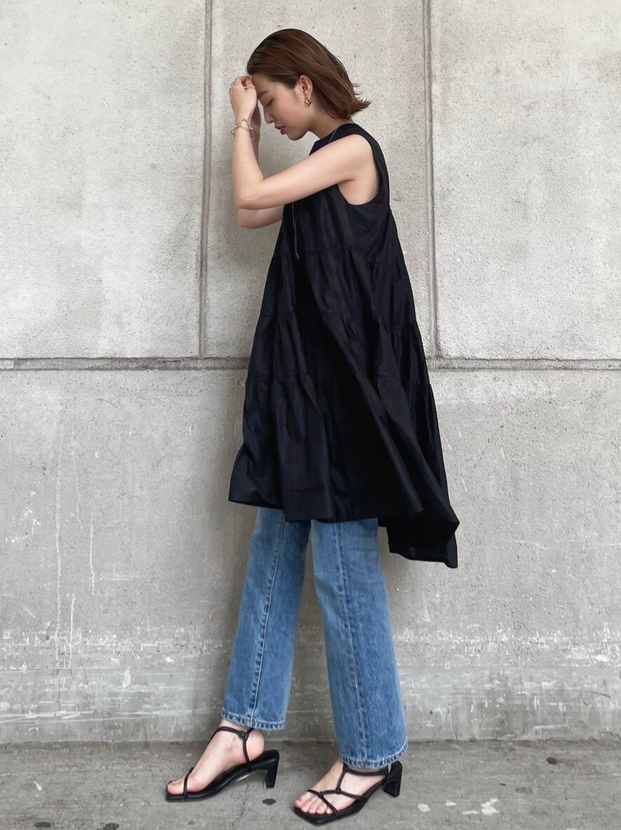 ブルー系のデニムパンツ、ブラック系のワンピース、ブラック系のサンダルを着用したレディースの夏コーディネートの2枚目の写真