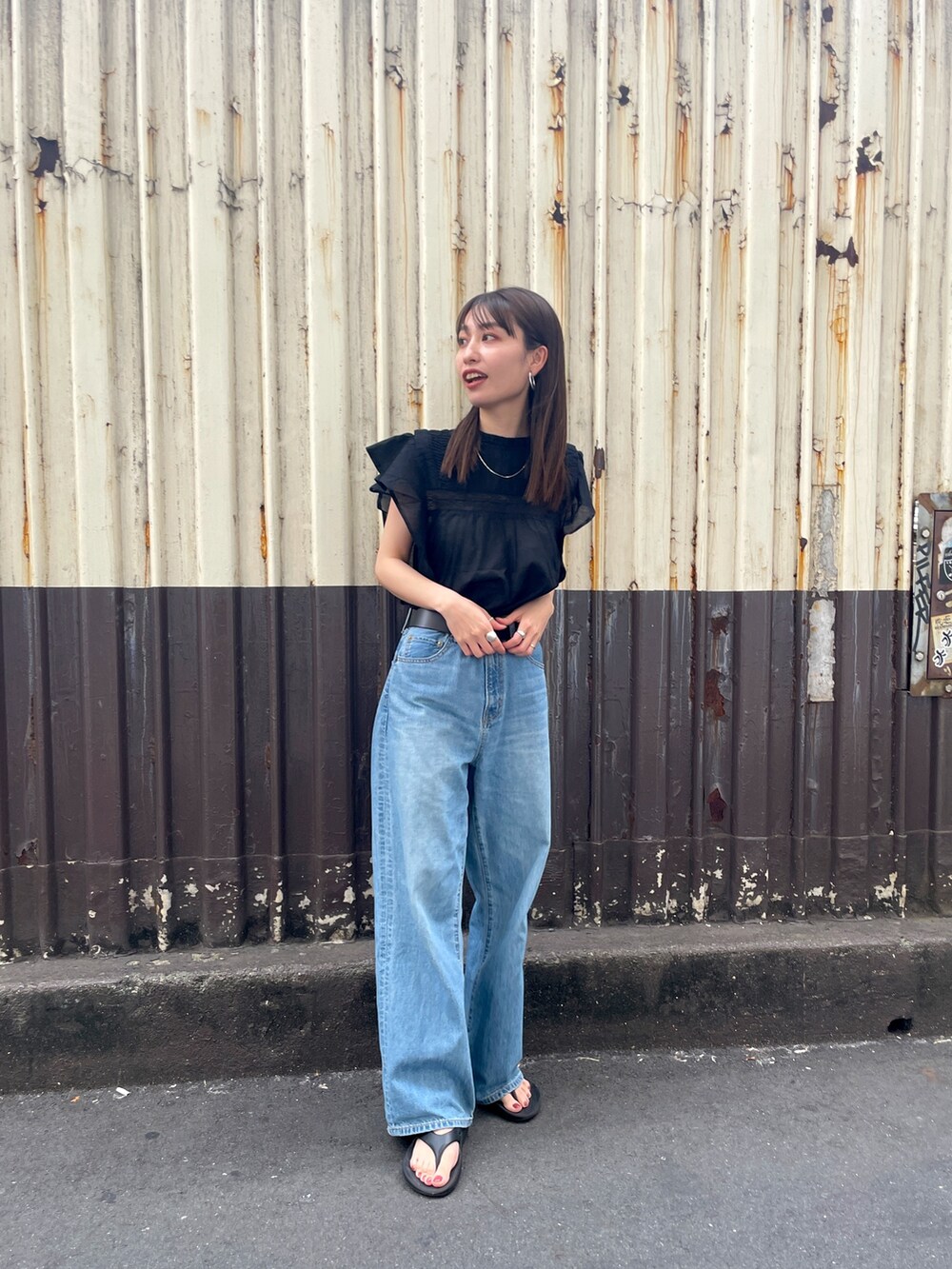 ブラック系のシャツ/ブラウス、ブルー系のデニムパンツを着用したレディースの春コーディネートの2枚目の写真