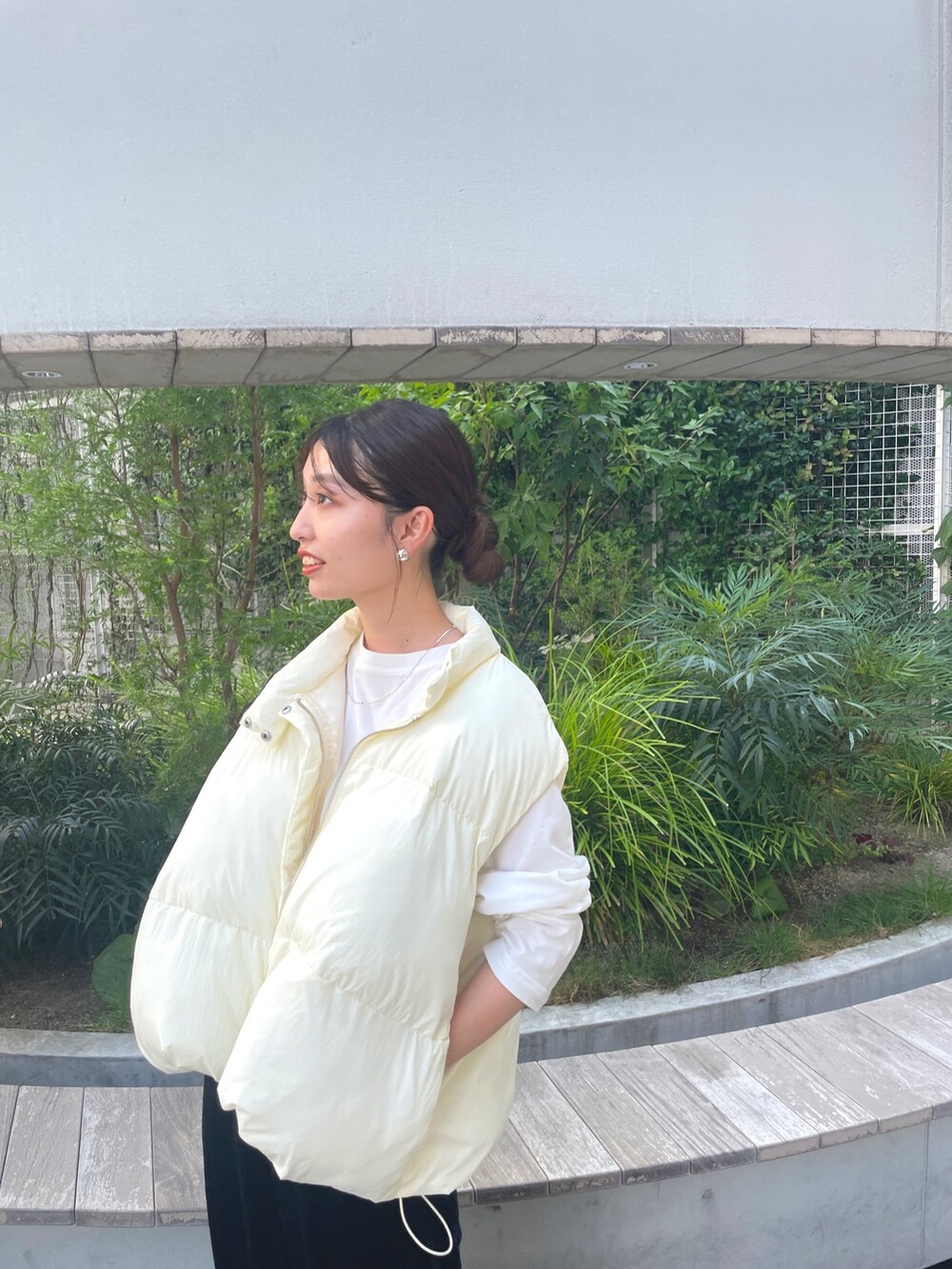 ホワイト系のダウンベスト、ホワイト系のTシャツ/カットソー、ブラック系のスカートを着用したレディースの秋コーディネートの3枚目の写真