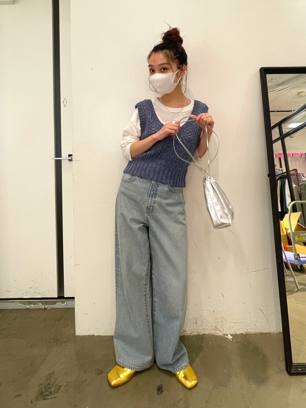 ブルー系のデニムパンツ、ゴールド系のパンプス、ホワイト系のTシャツ/カットソーを着用したレディースの冬コーディネートの2枚目の写真