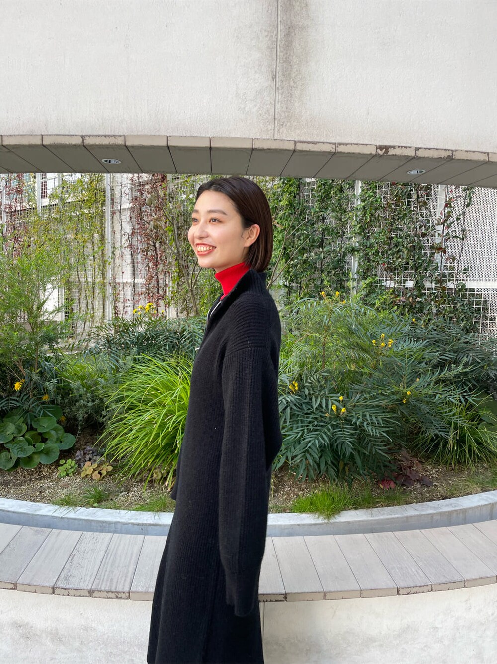 レッド系のニット/セーター、ブラック系のワンピースを着用したレディースの冬コーディネートの3枚目の写真