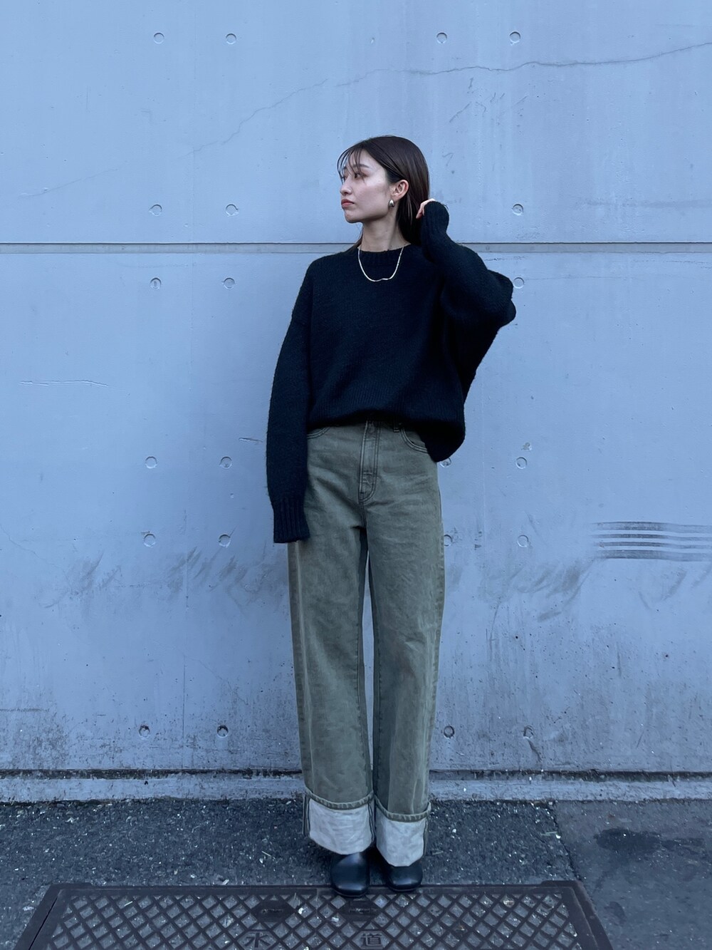 ブラック系のニット/セーター、グリーン系のデニムパンツを着用したレディースの冬コーディネートの2枚目の写真