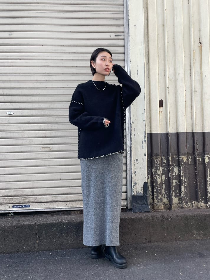 グレー系のスカート、ブラック系のニット/セーターを着用したレディースの冬コーディネートの3枚目の写真