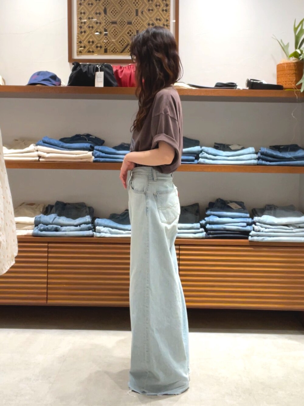 ブラウン系のTシャツ/カットソー、ブルー系のデニムパンツを着用したレディースの夏コーディネートの2枚目の写真