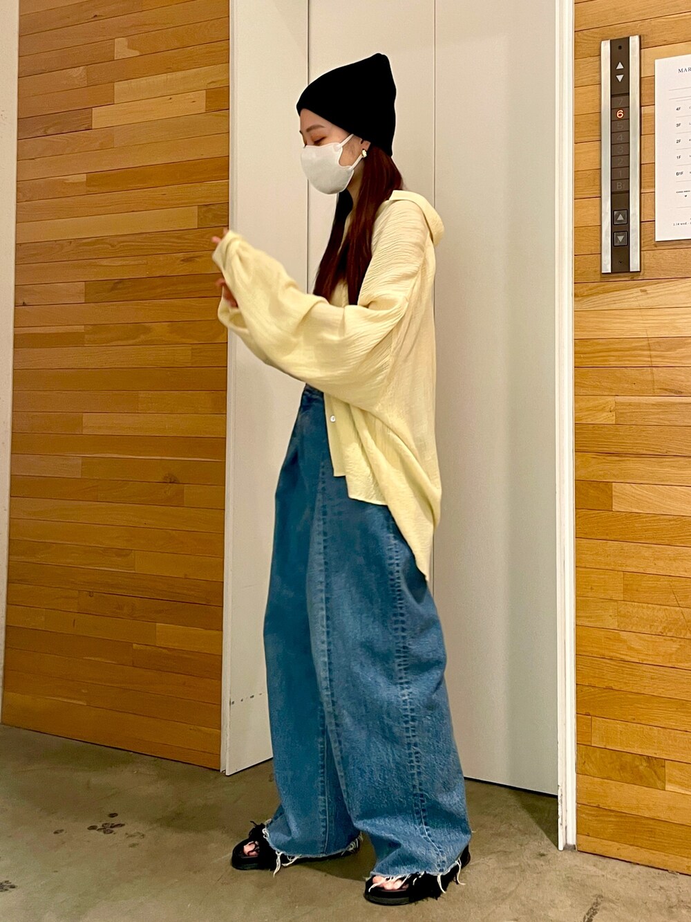 イエロー系のシャツ/ブラウス、ブルー系のデニムパンツ、ブラック系のサンダルを着用したレディースの春コーディネートの3枚目の写真