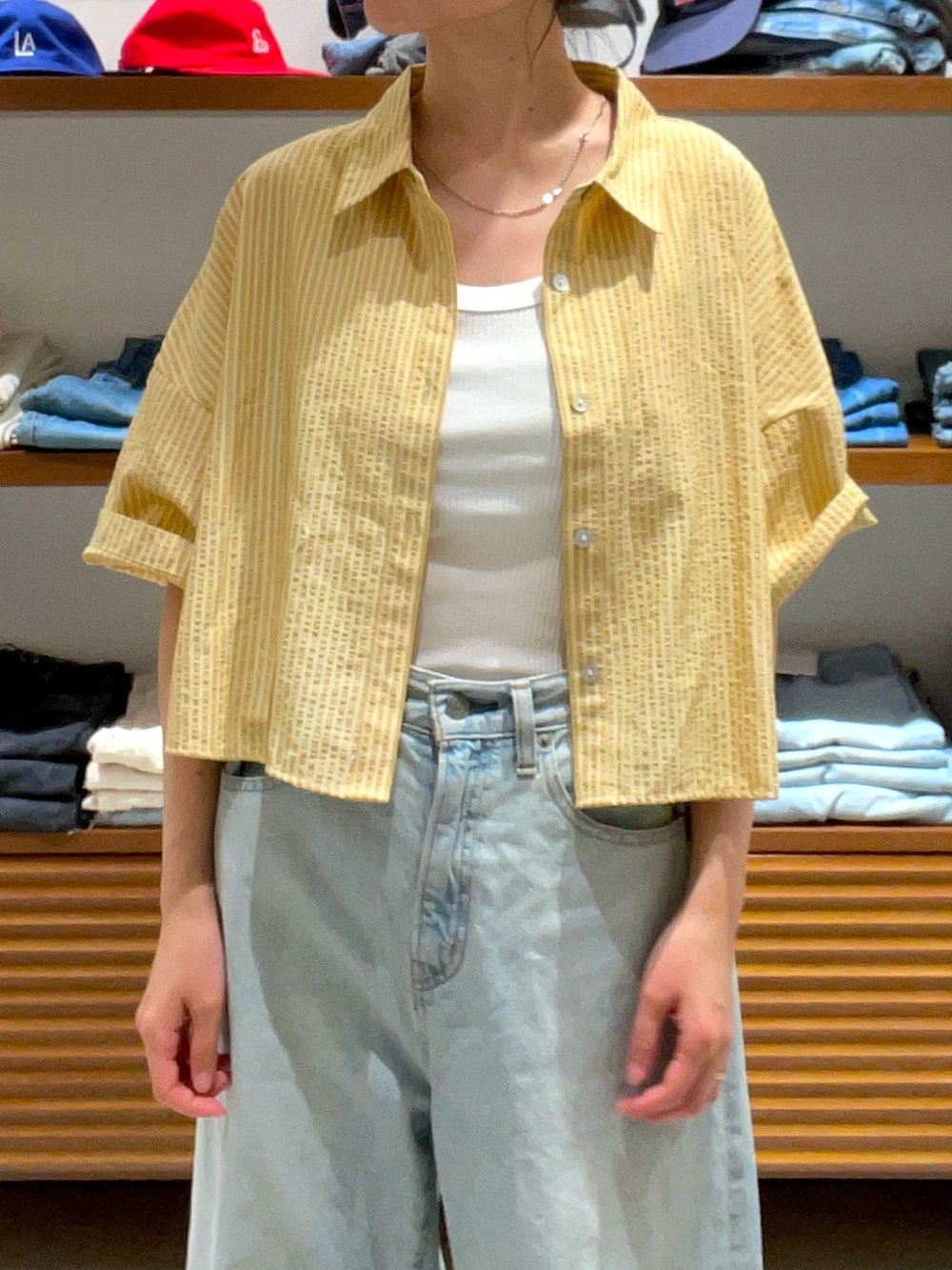 イエロー系のシャツ/ブラウス、ホワイト系のデニムパンツを着用したレディースの夏コーディネートの4枚目の写真
