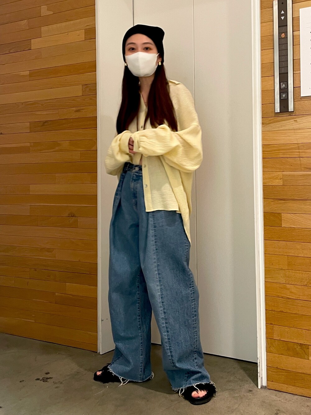 イエロー系のシャツ/ブラウス、ブルー系のデニムパンツ、ブラック系のサンダルを着用したレディースの春コーディネートの2枚目の写真