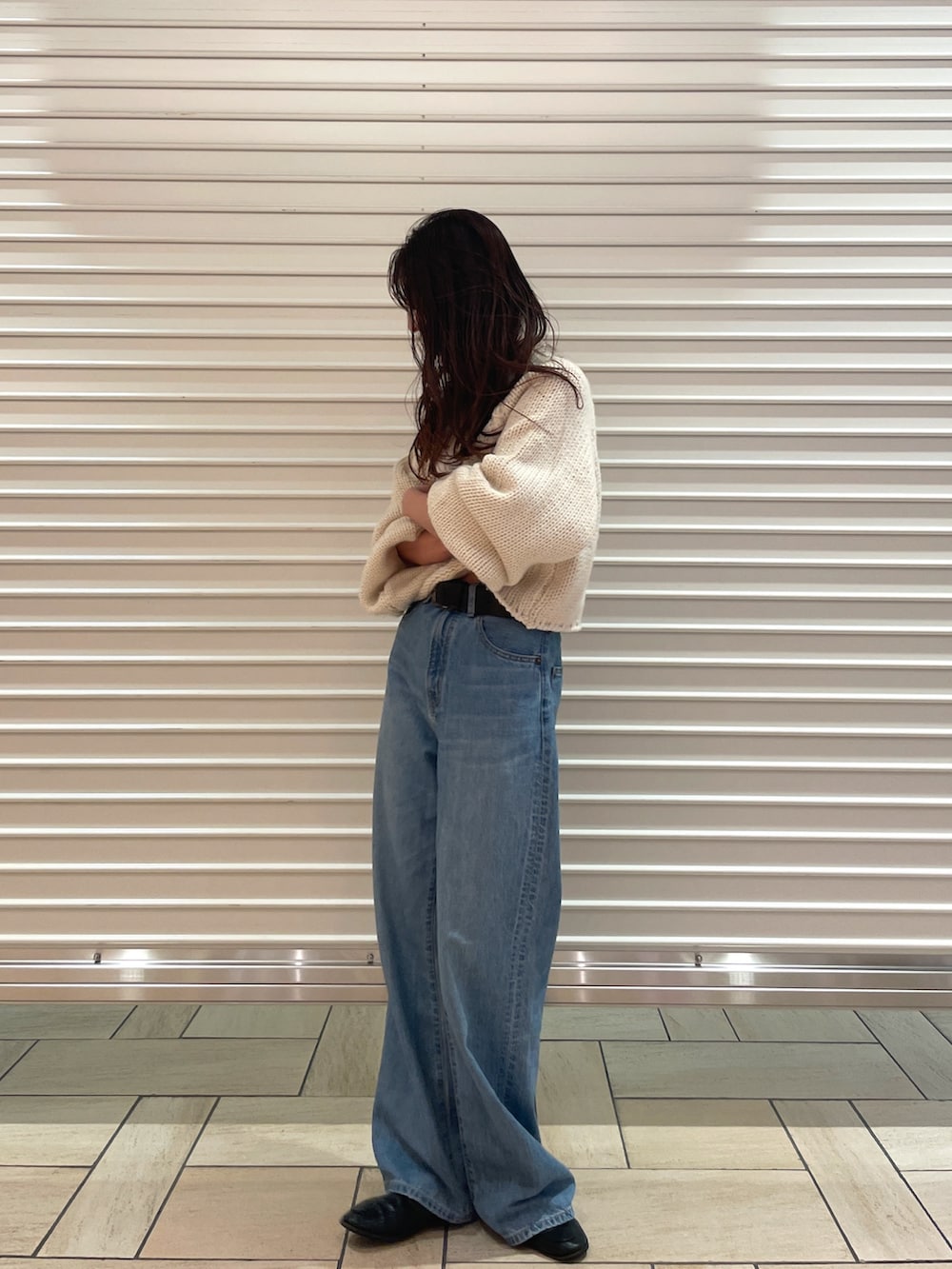 ホワイト系のニット/セーター、ブルー系のデニムパンツを着用したレディースの秋コーディネートの2枚目の写真