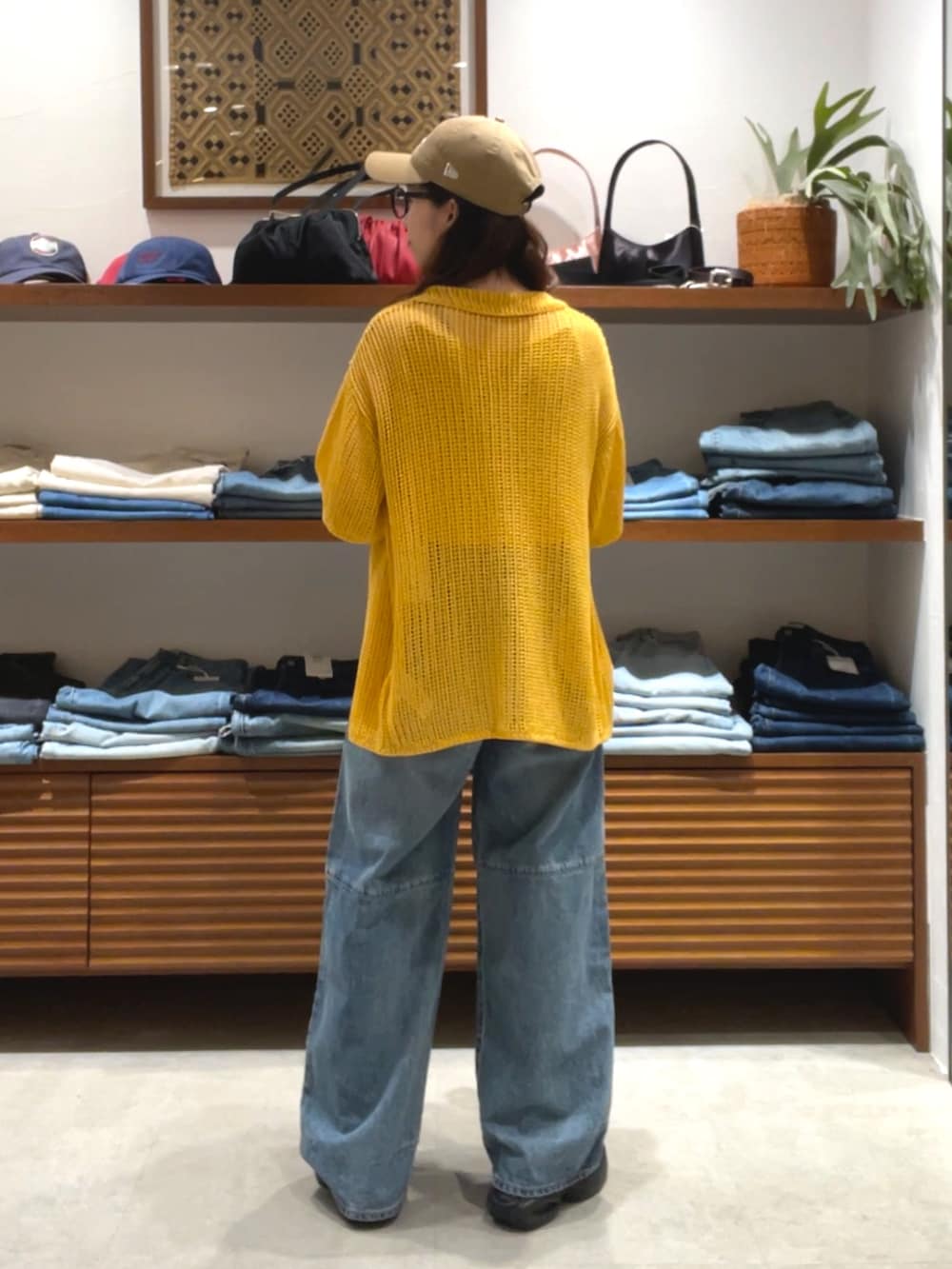 オレンジ系のカーディガン/ボレロ、ブルー系のデニムパンツを着用したレディースの春コーディネートの3枚目の写真