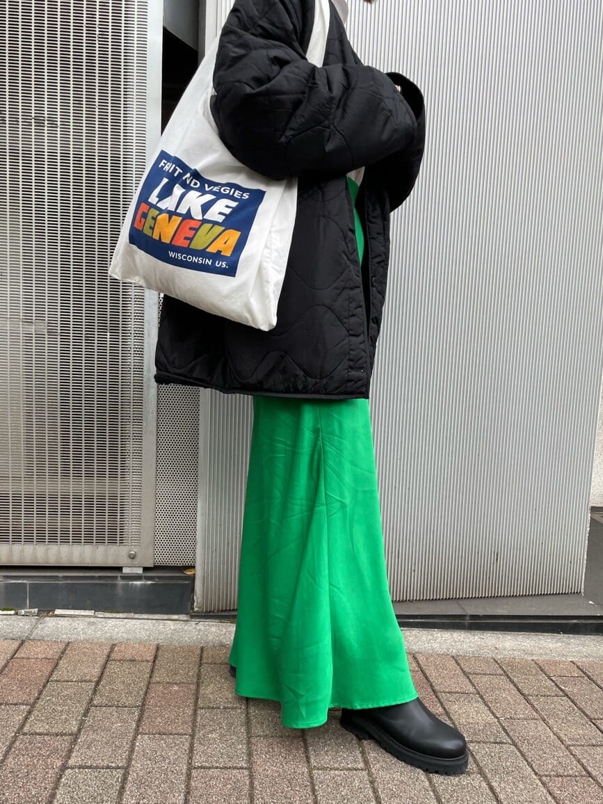 グリーン系のスカート、ブラック系のブーツ、ホワイト系のエコバッグ/サブバッグを着用したレディースの秋コーディネートの3枚目の写真
