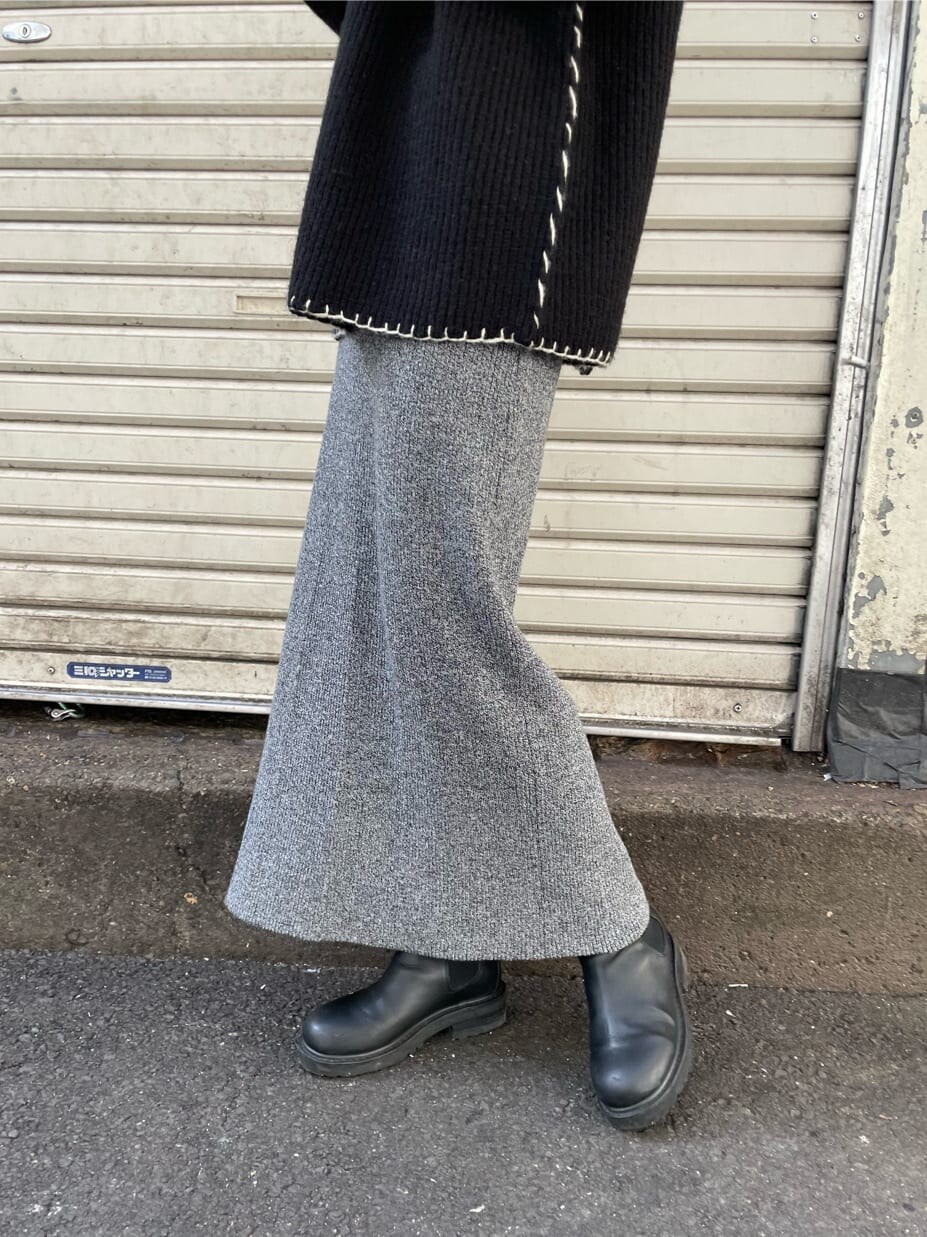 グレー系のスカート、ブラック系のニット/セーターを着用したレディースの冬コーディネートの4枚目の写真