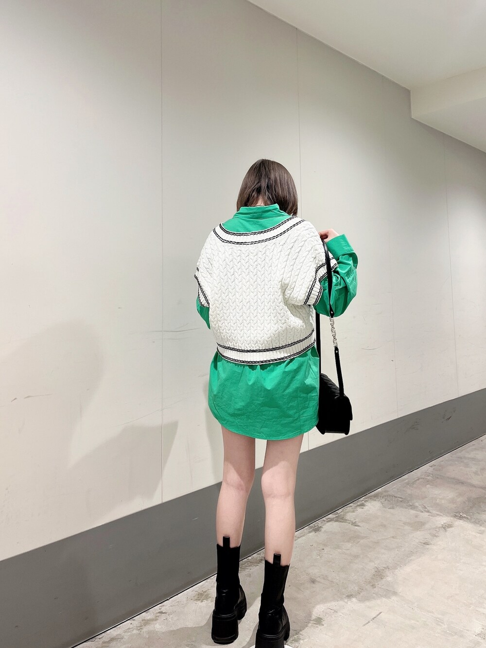 グリーン系のシャツ/ブラウス、ブラック系のショルダーバッグ、ブラック系のブーツを着用したレディースの冬コーディネートの2枚目の写真