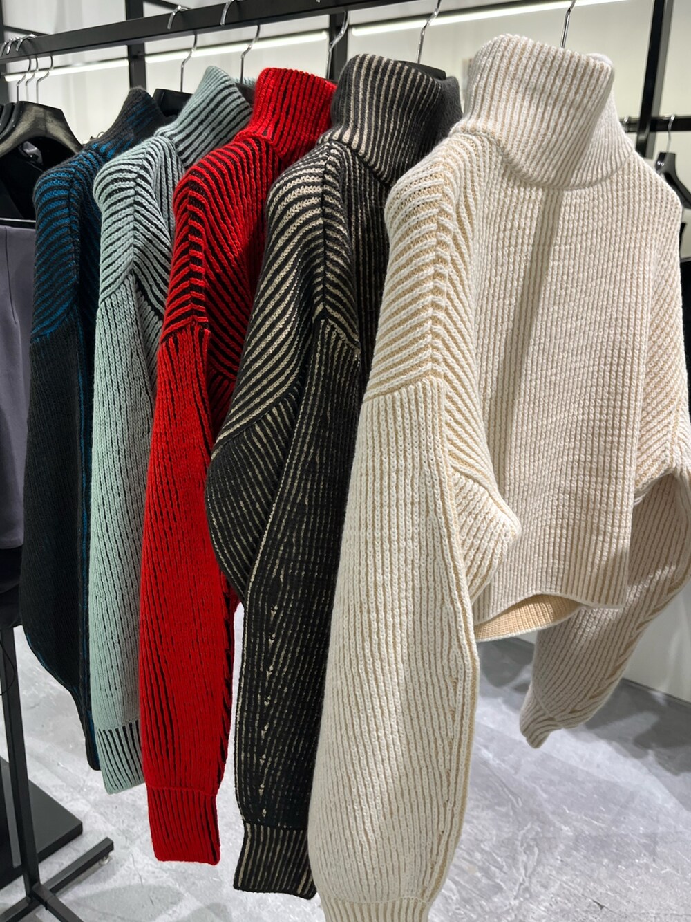 ブラック系のブルゾン、グリーン系のニット/セーター、ブラック系のスカートを着用したレディースの秋コーディネートの3枚目の写真