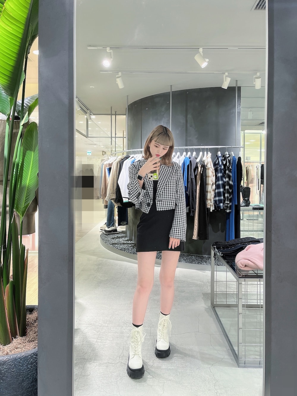 ホワイト系のブーツ、その他のテーラードジャケット、ブラック系のスカートを着用したレディースの冬コーディネートの2枚目の写真