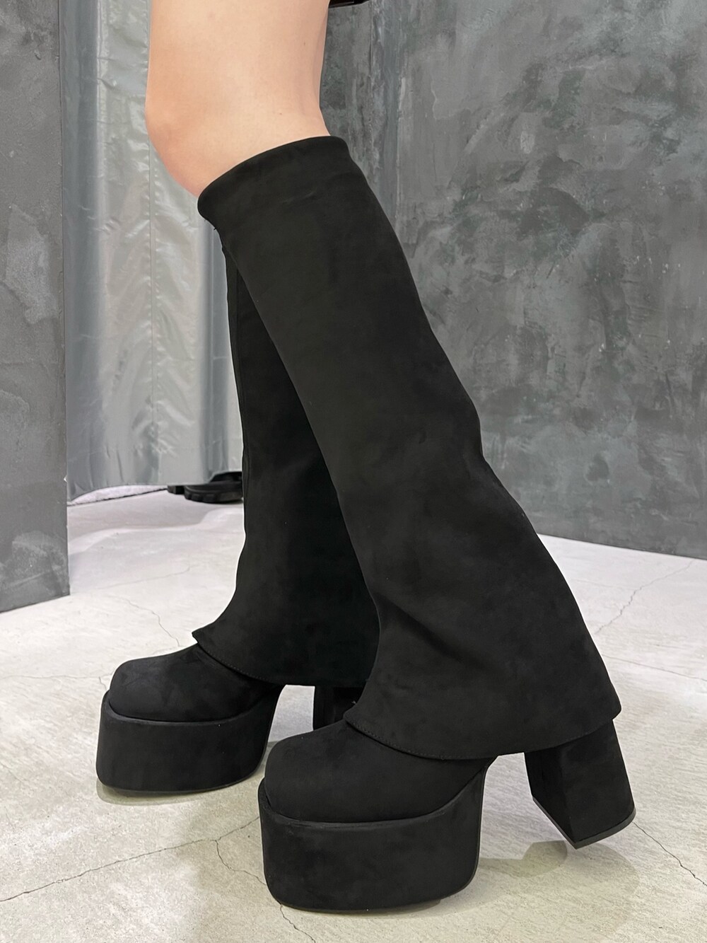 ブラック系のスカート、ブラック系のブーツ、グレー系のニット/セーターを着用したレディースの秋コーディネートの4枚目の写真