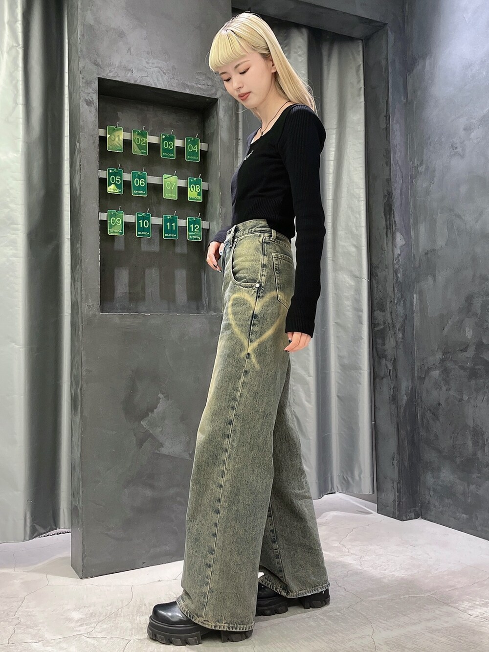 ブラック系のニット/セーター、ブルー系のデニムパンツ、ブラック系のブーツを着用したレディースの冬コーディネートの2枚目の写真