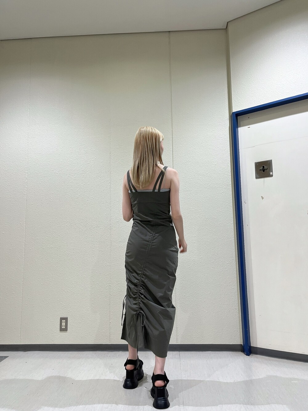 グリーン系のワンピース、ブラック系のサンダル、ブラック系のネックレスを着用したレディースの春コーディネートの4枚目の写真