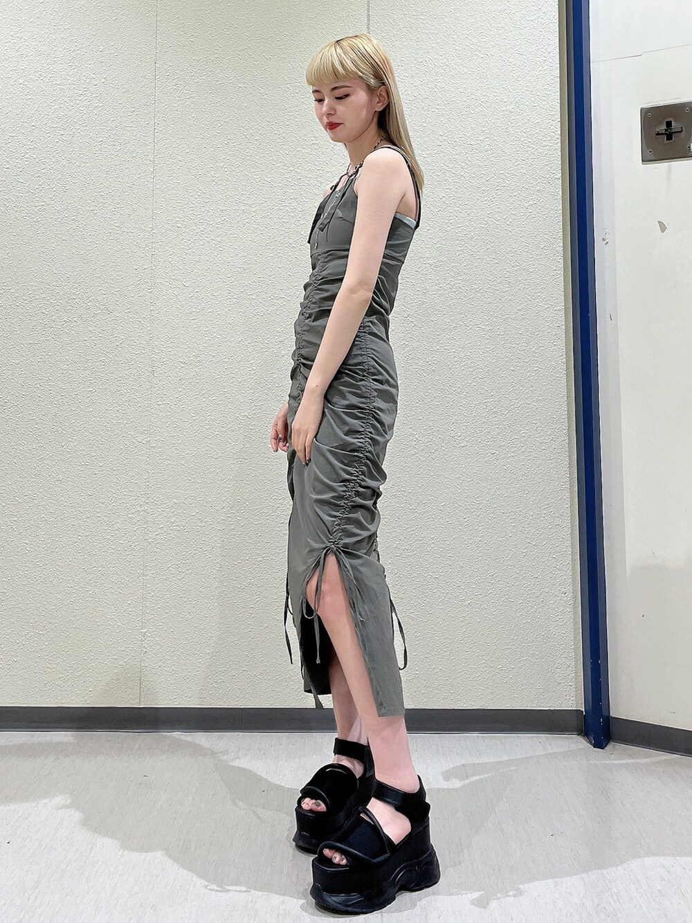 グリーン系のワンピース、ブラック系のサンダル、ブラック系のネックレスを着用したレディースの春コーディネートの2枚目の写真