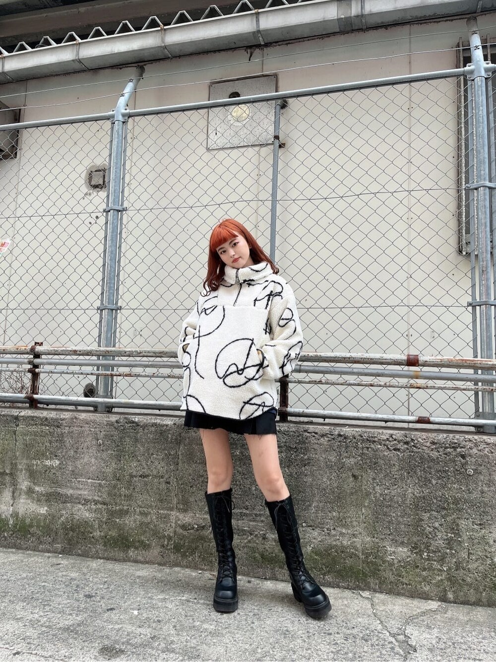 ブラック系のブーツ、ブラック系のスカート、その他のTシャツ/カットソーを着用したレディースの秋コーディネートの2枚目の写真