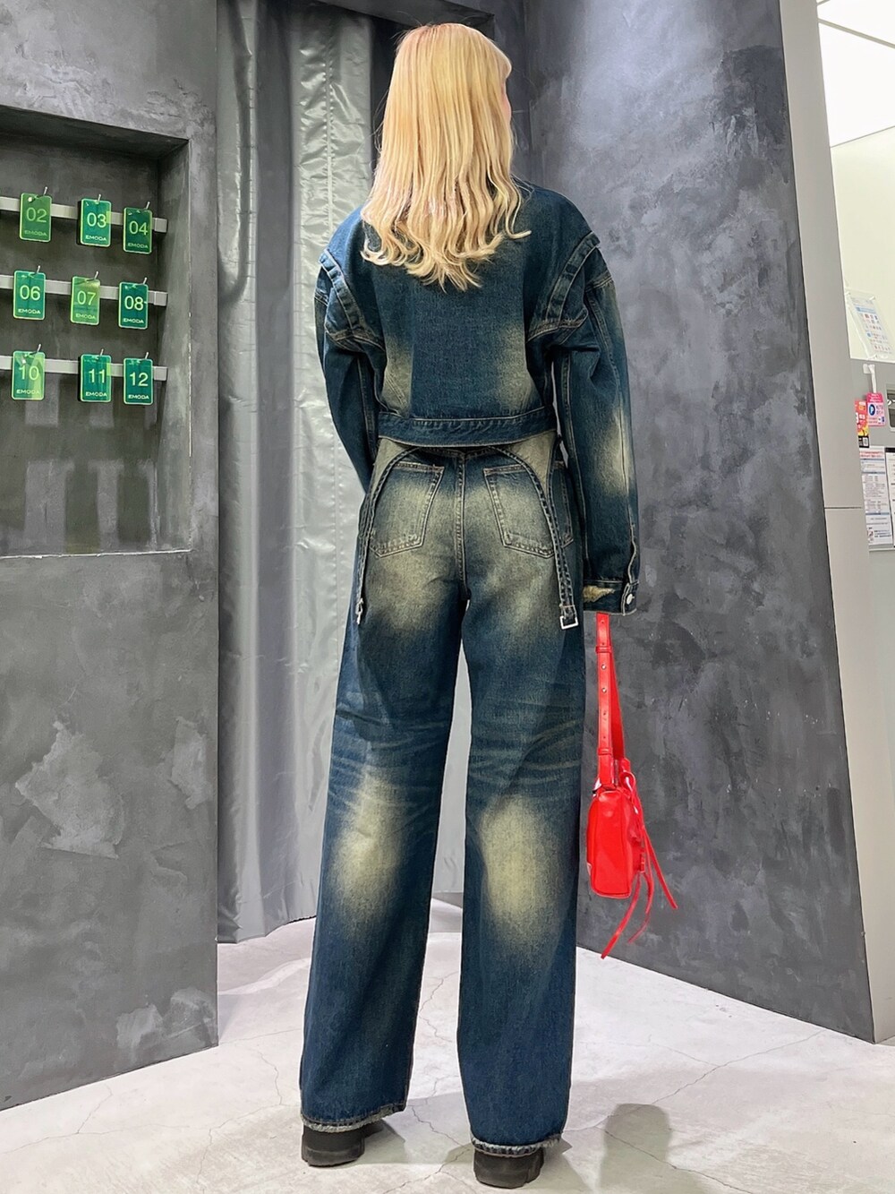 ブルー系のデニムパンツ、ブルー系のデニムジャケット、ブラック系のブーツを着用したレディースの秋コーディネートの3枚目の写真