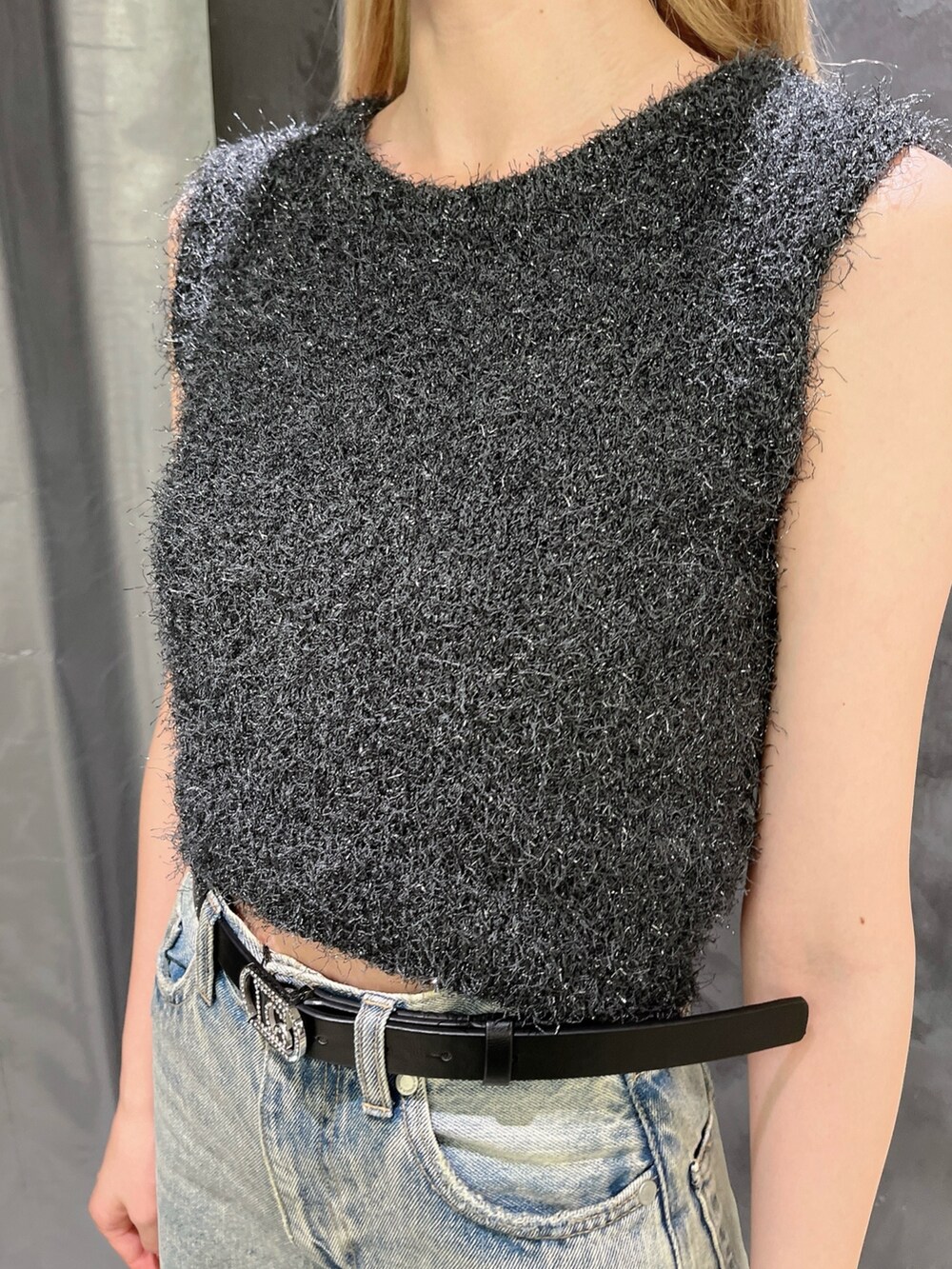 ブルー系のデニムパンツ、ブラック系のサンダル、グレー系のタンクトップを着用したレディースの夏コーディネートの4枚目の写真