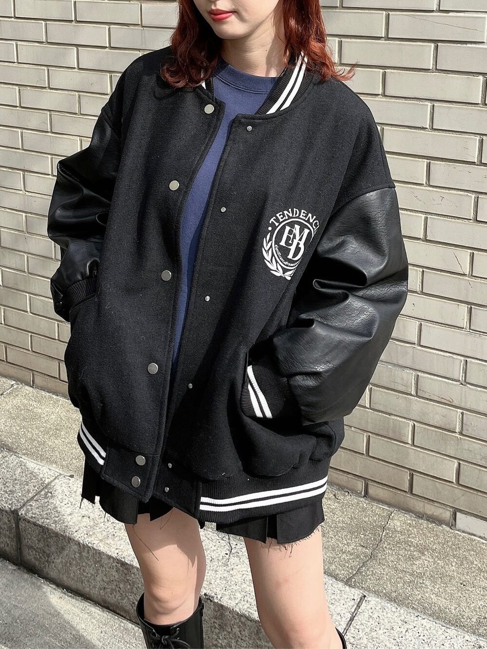 ブラック系のスカート、ブルー系のスウェット、ブラック系のブルゾンを着用したレディースの秋コーディネートの3枚目の写真