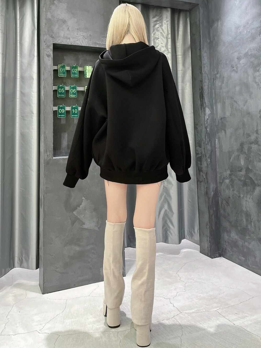 ブラック系のパーカー、その他のスカート、ホワイト系のブーツを着用したレディースの秋コーディネートの3枚目の写真