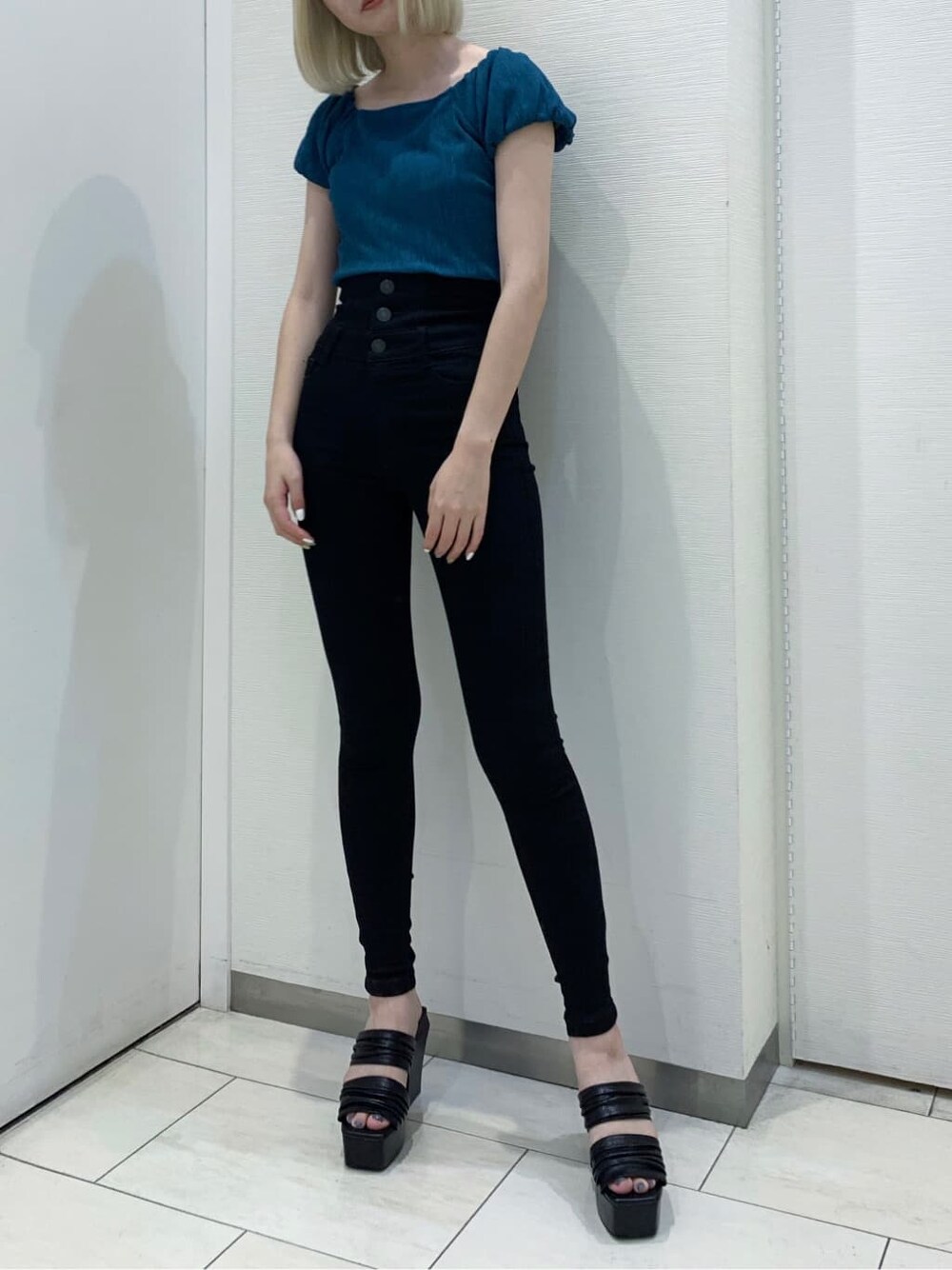 ブラック系のデニムパンツ、ブラック系のサンダル、ブルー系のTシャツ/カットソーを着用したレディースの夏コーディネートの3枚目の写真