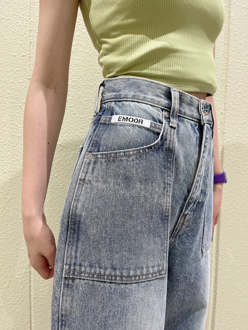 イエロー系のタンクトップ、ブルー系のデニムパンツ、ブラック系のサンダルを着用したレディースの夏コーディネートの4枚目の写真