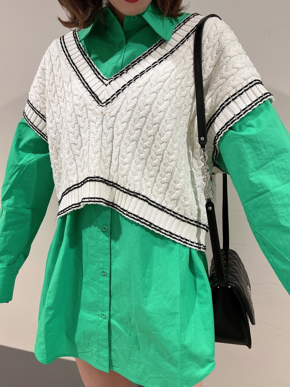 グリーン系のシャツ/ブラウス、ブラック系のショルダーバッグ、ブラック系のブーツを着用したレディースの冬コーディネートの3枚目の写真