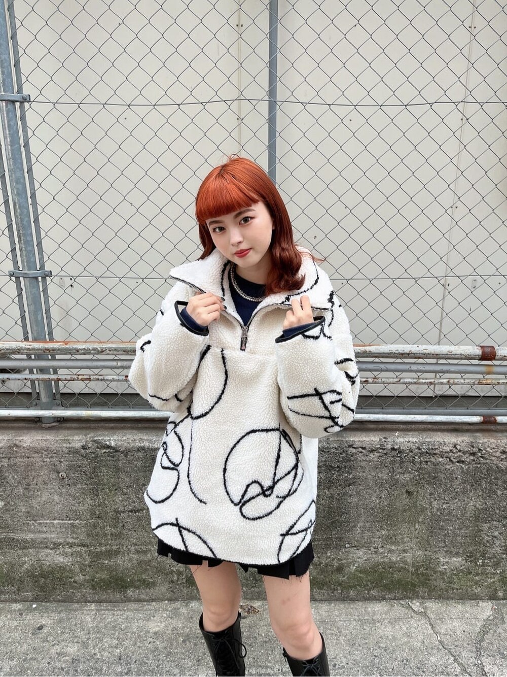 ブラック系のブーツ、ブラック系のスカート、その他のTシャツ/カットソーを着用したレディースの秋コーディネートの3枚目の写真