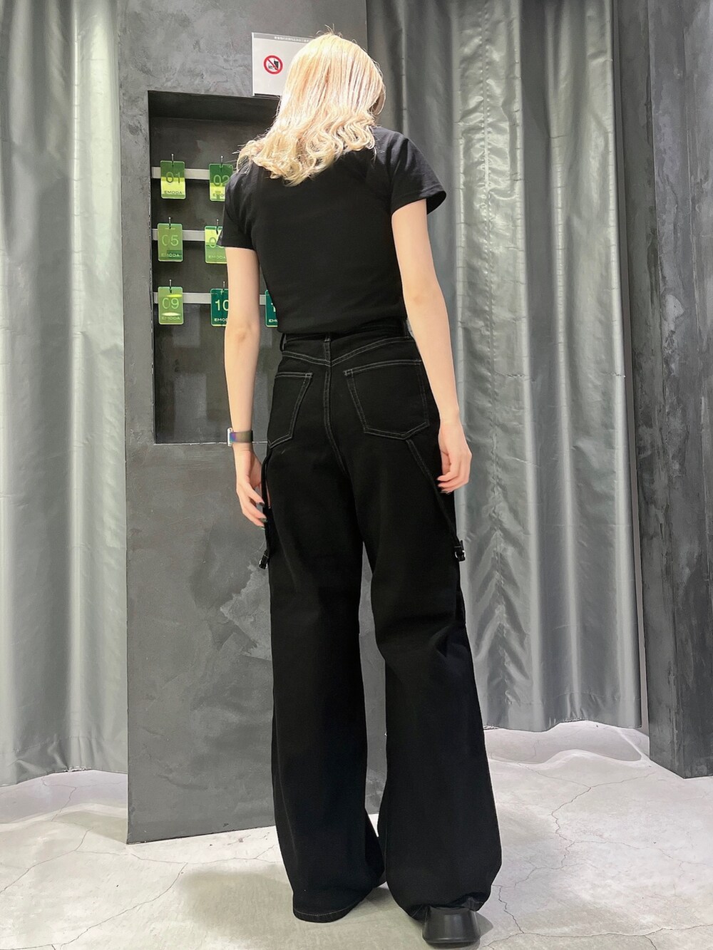 ブラック系のデニムパンツ、ブラック系のTシャツ/カットソー、ブラック系のサンダルを着用したレディースの夏コーディネートの3枚目の写真