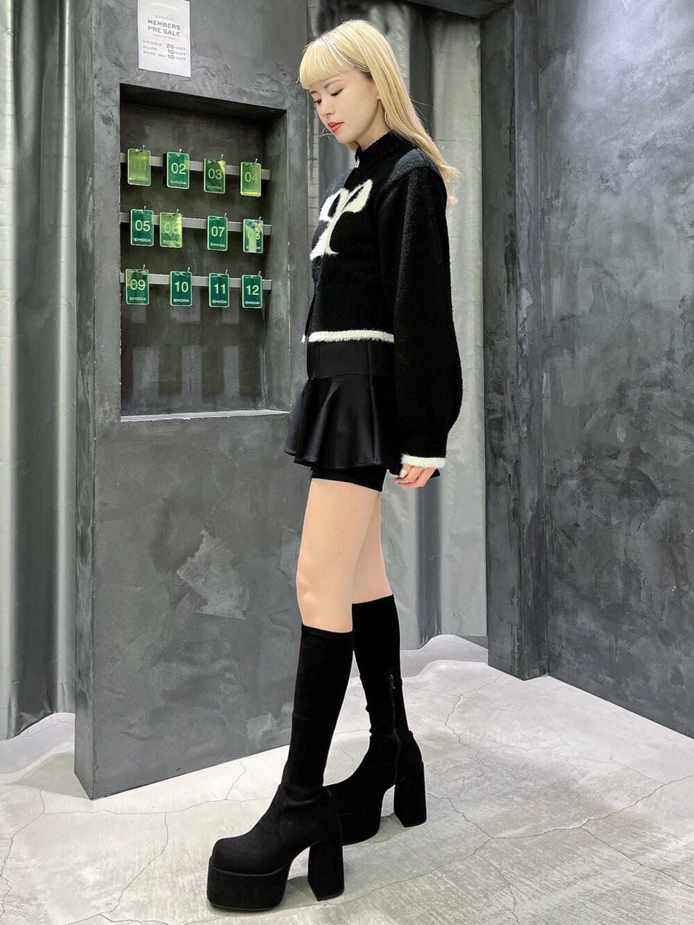 ブラック系のニット/セーター、ブラック系のスカート、その他のブーツを着用したレディースの冬コーディネートの2枚目の写真