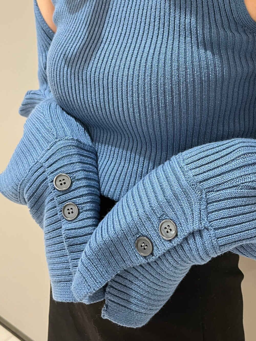 ブルー系のニット/セーター、ブラック系のスカート、ブラック系のブーツを着用したレディースの秋コーディネートの3枚目の写真