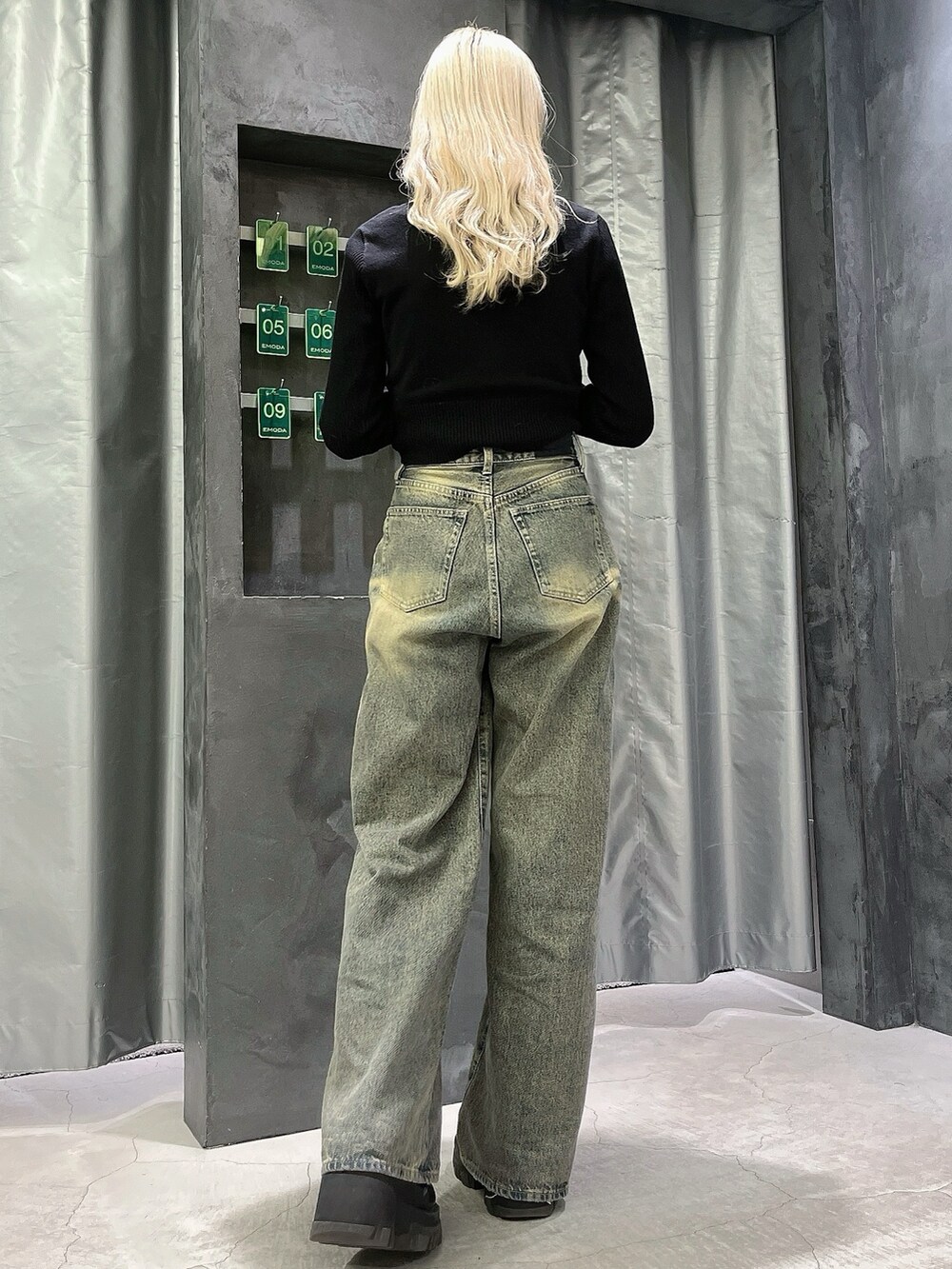 ブラック系のニット/セーター、ブルー系のデニムパンツ、ブラック系のブーツを着用したレディースの冬コーディネートの3枚目の写真